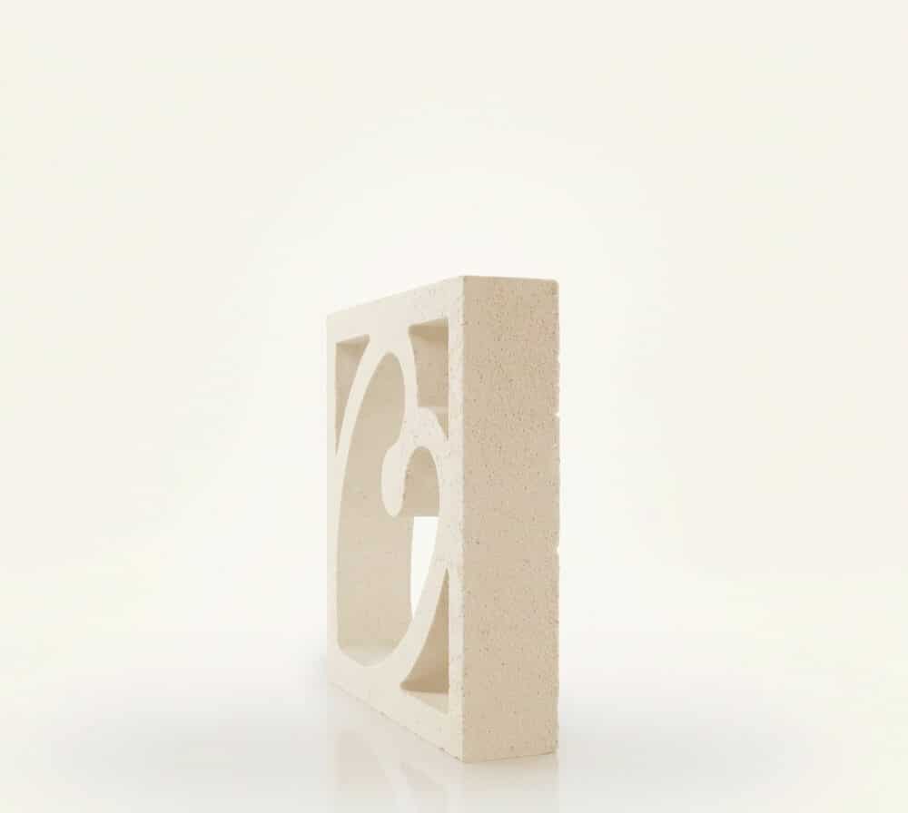 Celosía blanca de hormigón con diseño de corazón. Presenta una textura granulada y está sobre fondo blanco.