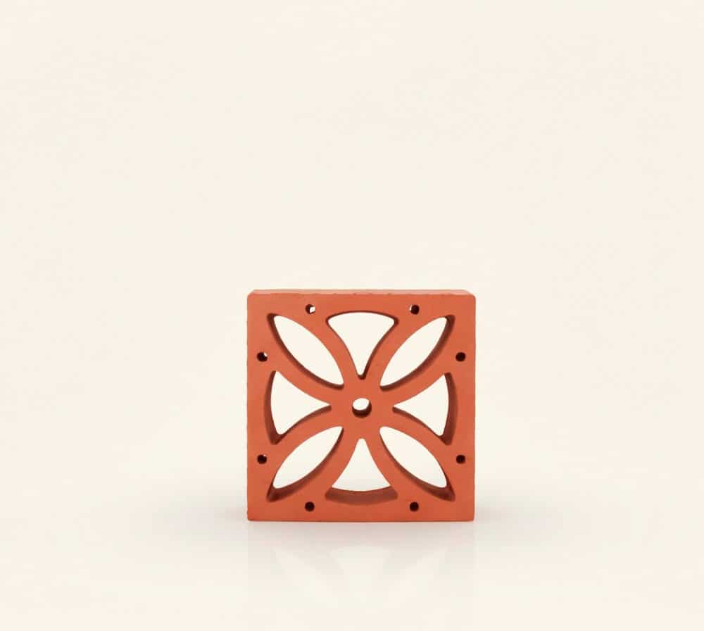 Esta celosía flor de cerámica terracota presenta un diseño calado de cuatro pétalos.