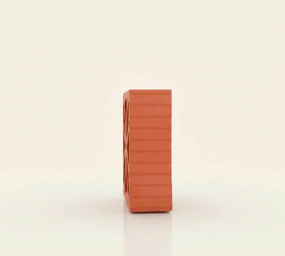 Celosía flor de ladrillo terracota con patrón decorativo sobre fondo blanco.
