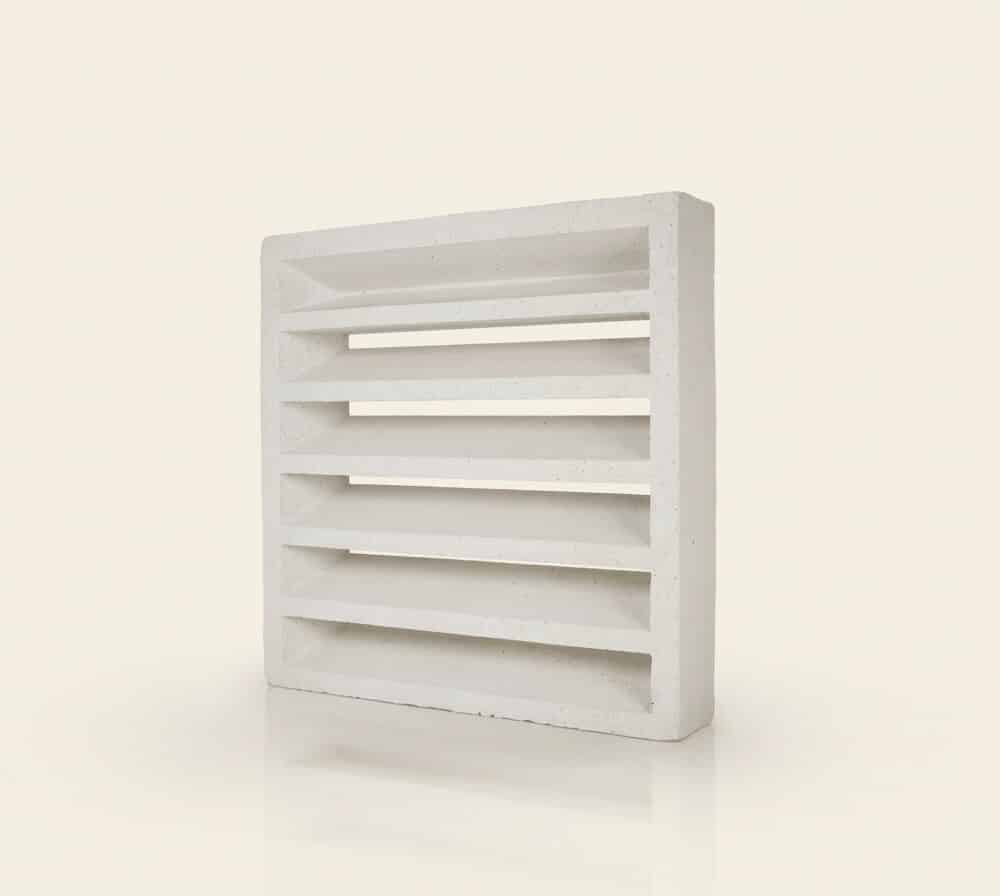 Una celosía persiana grande de hormigón blanco con múltiples lamas horizontales.