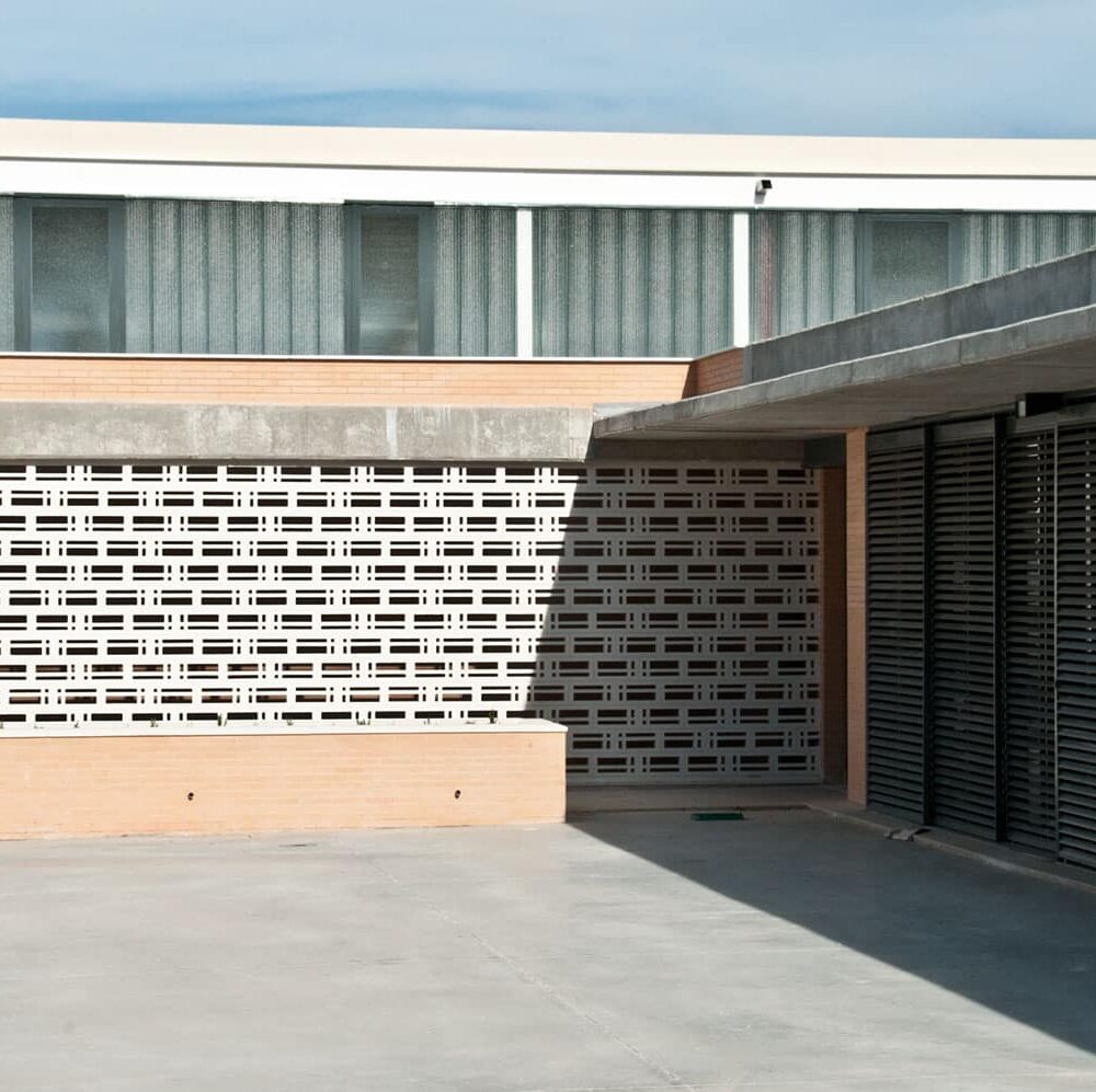 Celosia Paula blanca con patrón geométrico en la fachada de un edificio moderno.