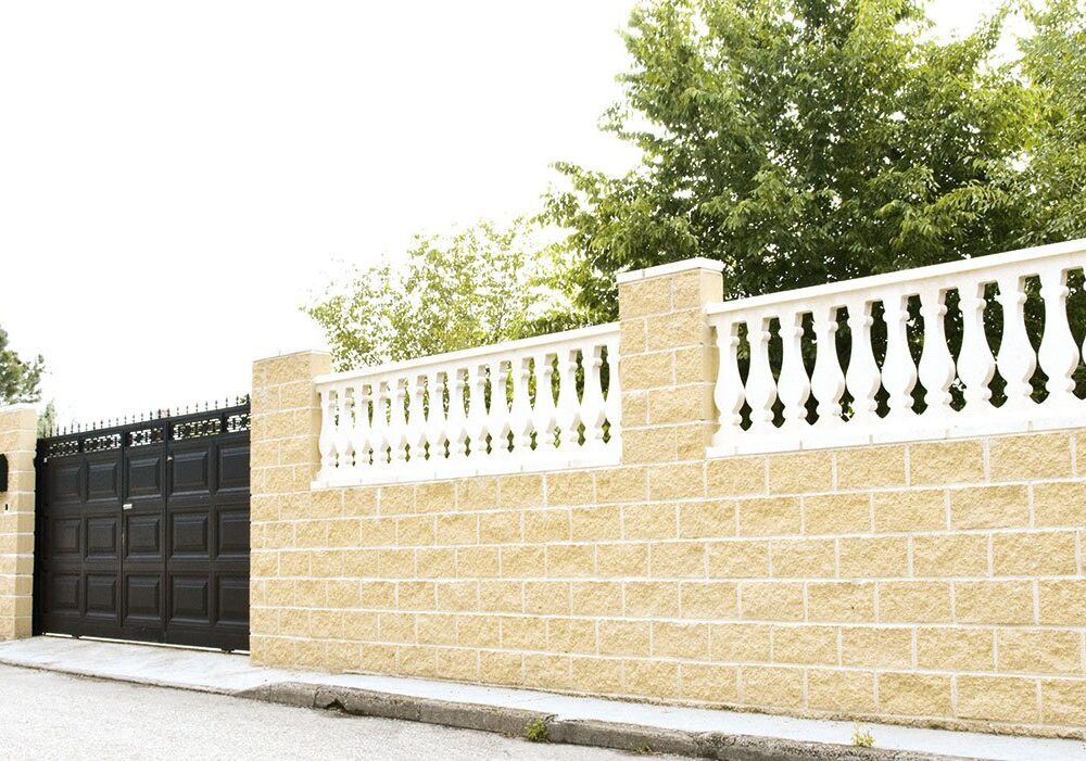 Muro exterior con balaustres decorativos y cubremuros en zona residencial
