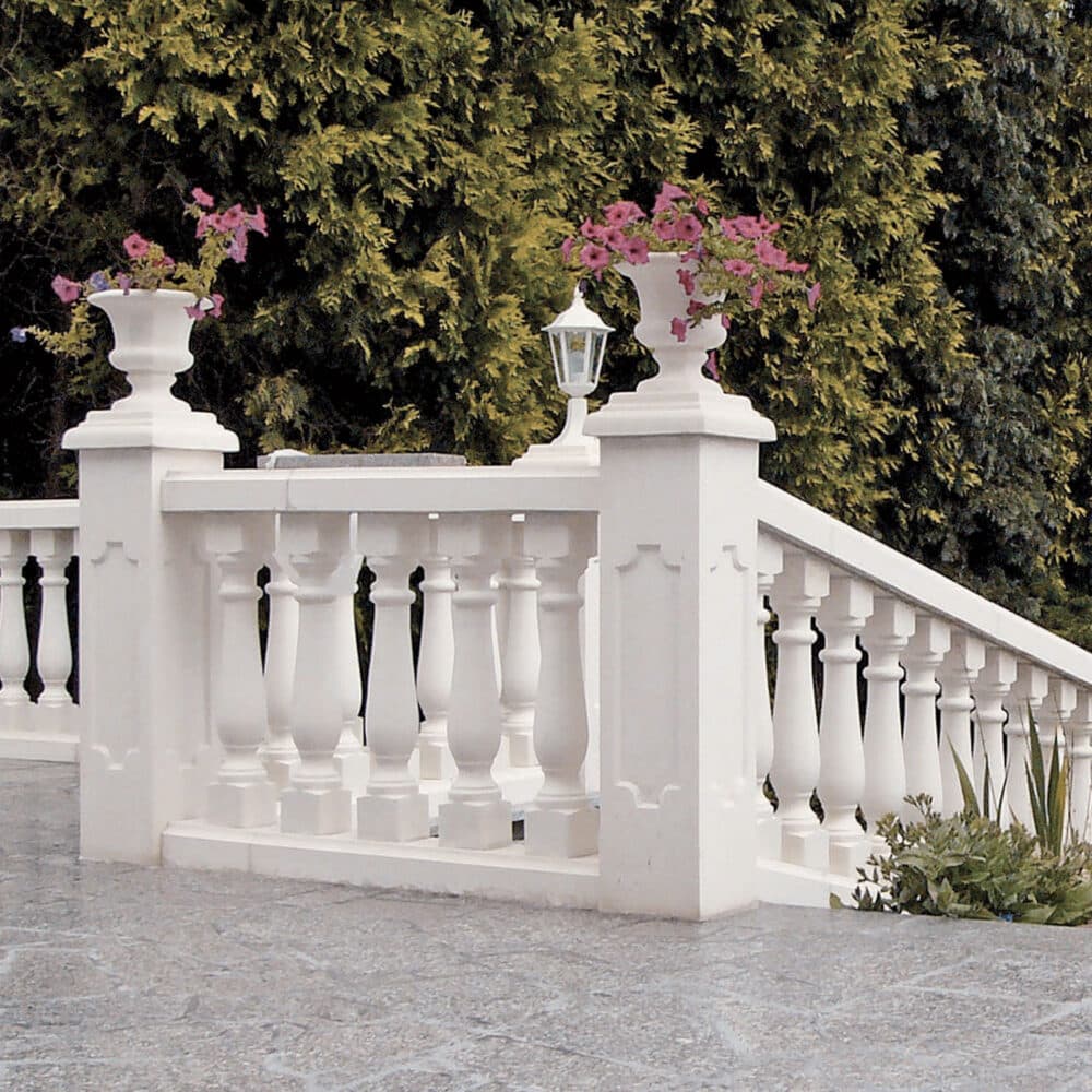 Balaustrada blanca con macetas y farol sobre terraza de piedra