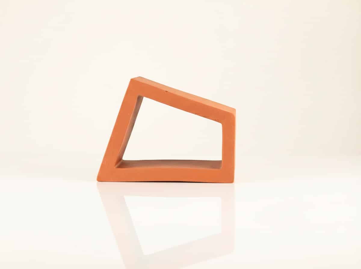 Pieza de celosía cerámica roja tetra sienna para terraza. Presenta forma irregular y reflejo.