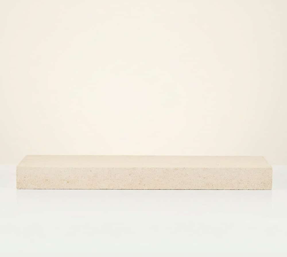 Pasamanos rectangular de hormigón color beige claro sobre fondo neutro.