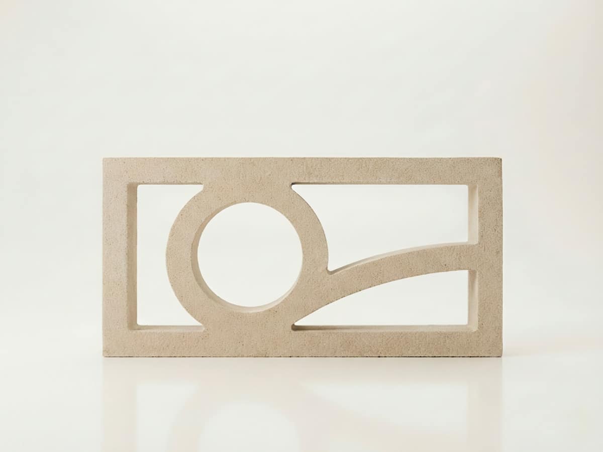 Bloque de celosía de hormigón beige con diseño geométrico de círculo y curva. Es una celosia terraza.